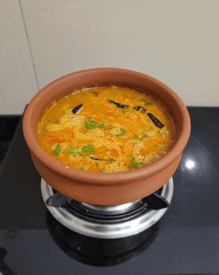 A bowl of homemade kollu rasam made with horse gram, served hot with coriander.