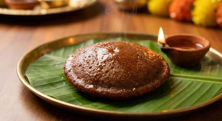 Nei Appam served on banana leaf with oil lamp for Karthigai Deepam prasadam.