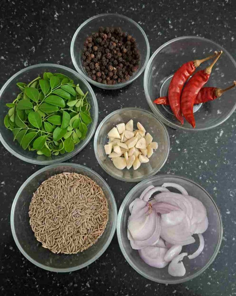 Murungai keerai soup ingredients including murungai keerai leaves, pepper, cumin seeds, garlic, onion and dry red chilli