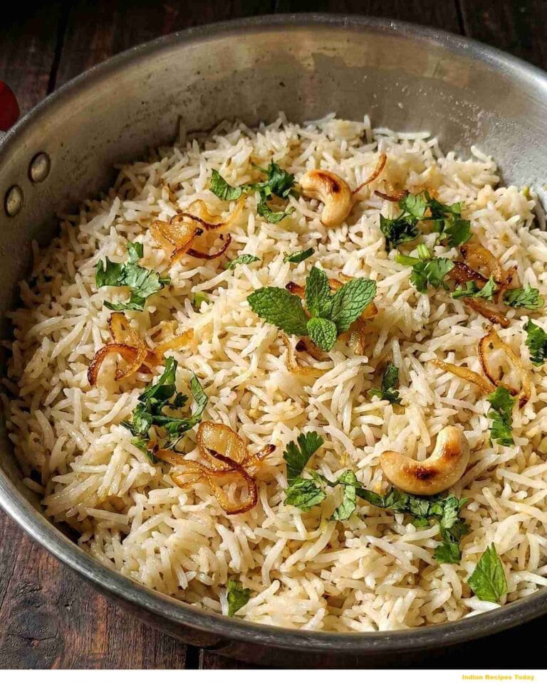 Thengai Paal Sadam Coconut Milk Pulao served in a pan with fried onions, roasted cashews and mint garnish – South Indian Tamil style.