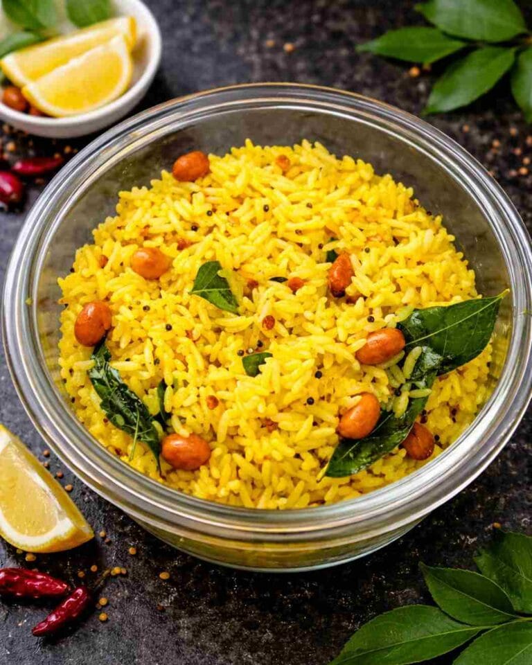 South Indian lemon rice in a bowl topped with crunchy roasted peanuts, mustard seeds, and curry leaves.