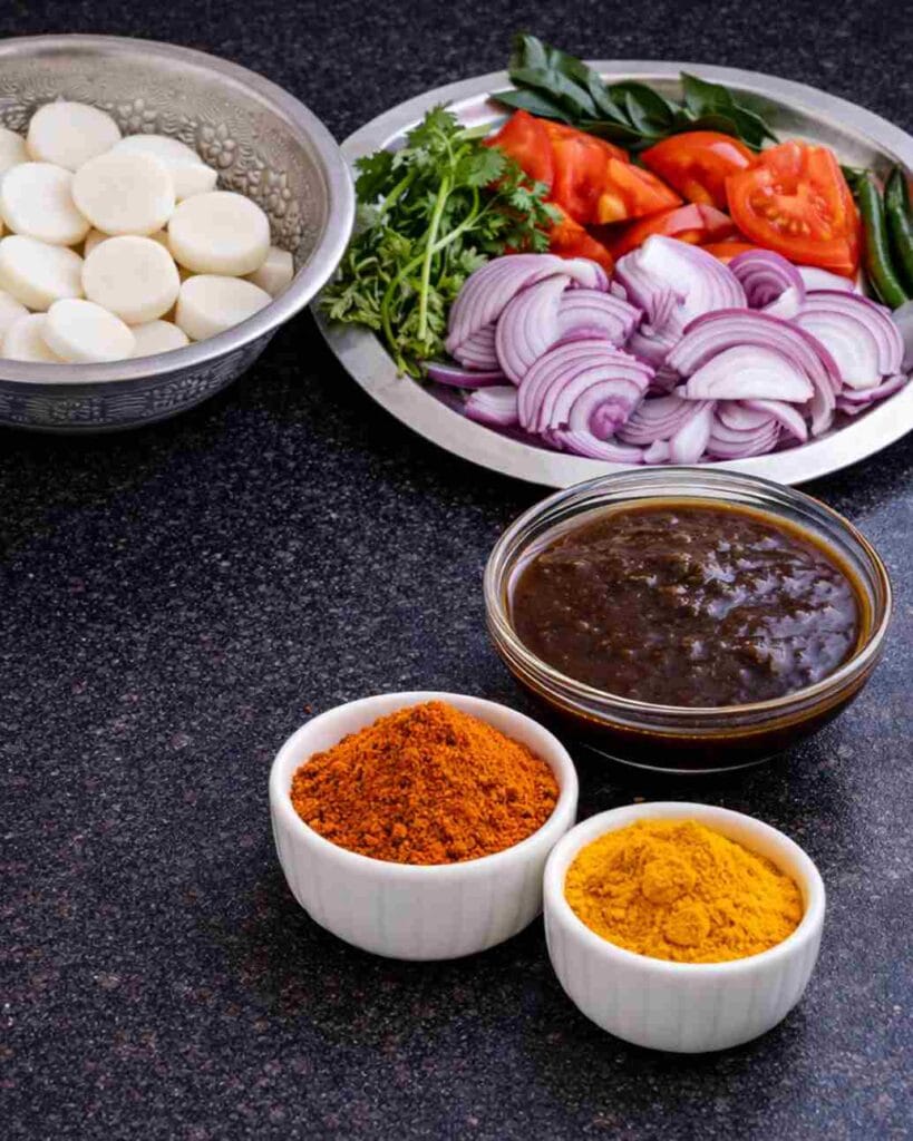 Fresh ingredients for mullangi sambar recipe including sliced radish, onion, tomato, tamarind extract and sambar powder
