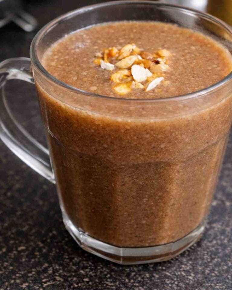 Karuppu ulundhu kanji served warm in a glass mug topped with roasted nuts for a high protein breakfast