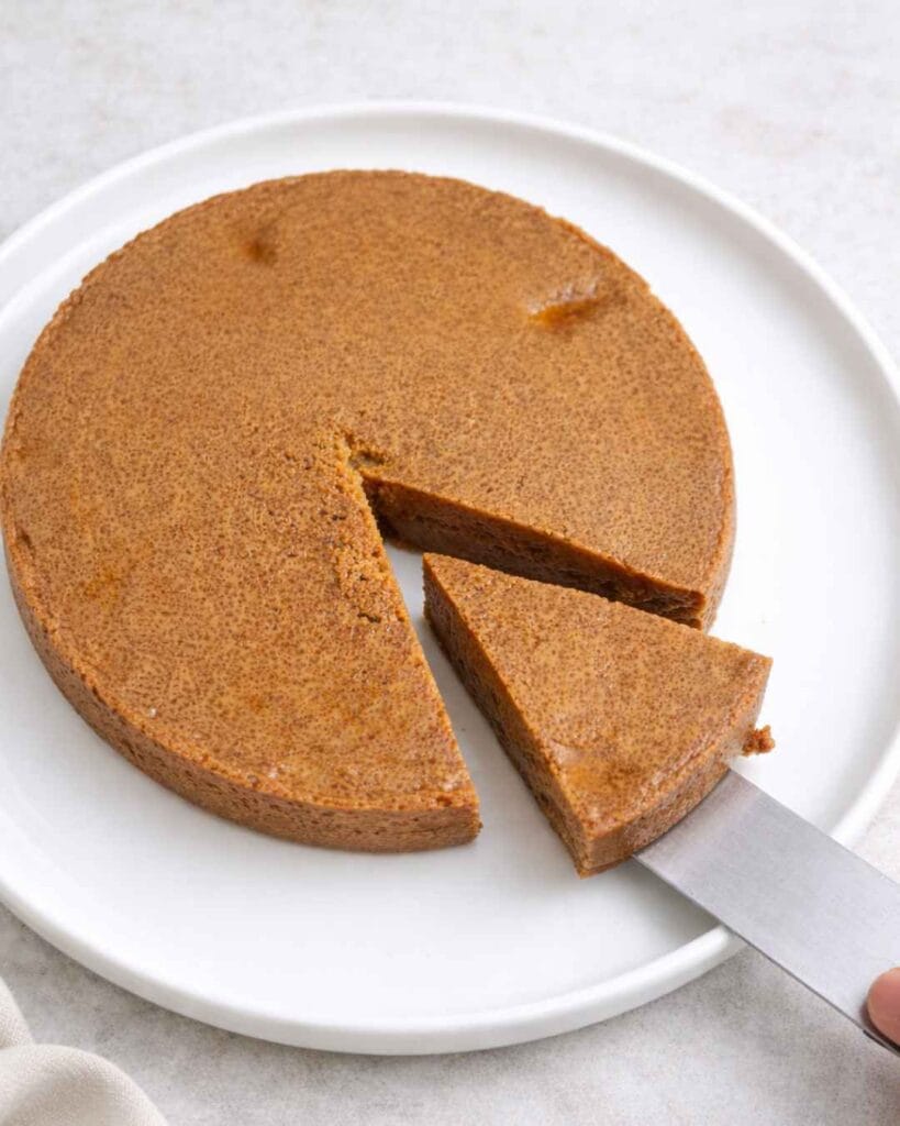 Sliced wattalappam showing soft texture on white plate (வட்டலப்பம் coconut pudding)