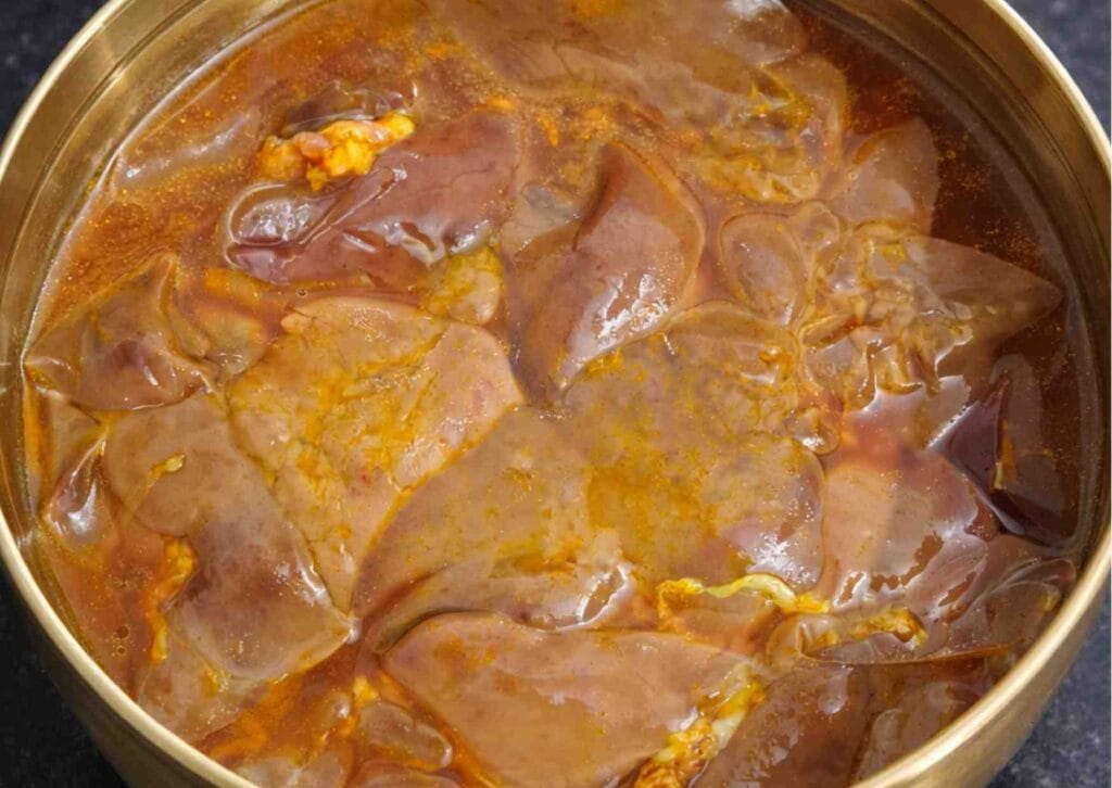 chicken liver soaking in turmeric water in bowl