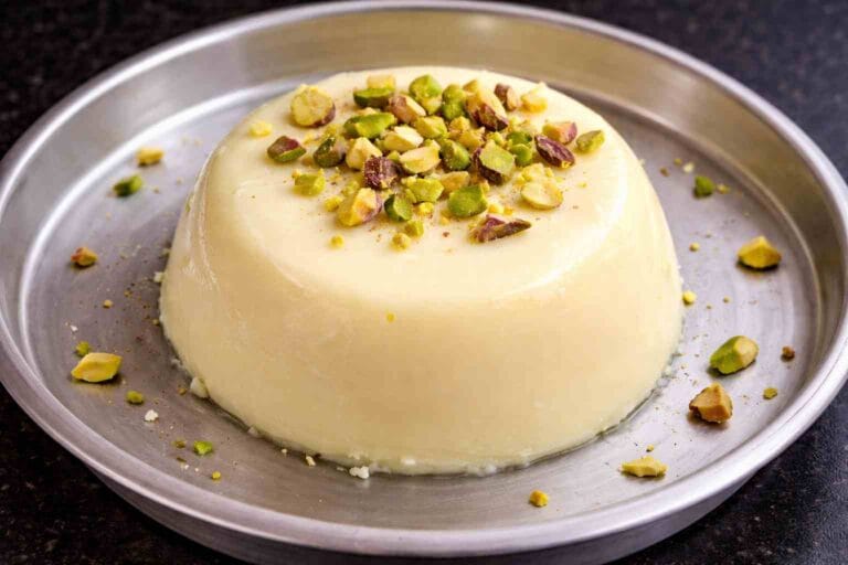 Coconut pudding with condensed milk without agar agar garnished with pistachios served as a soft and creamy dessert