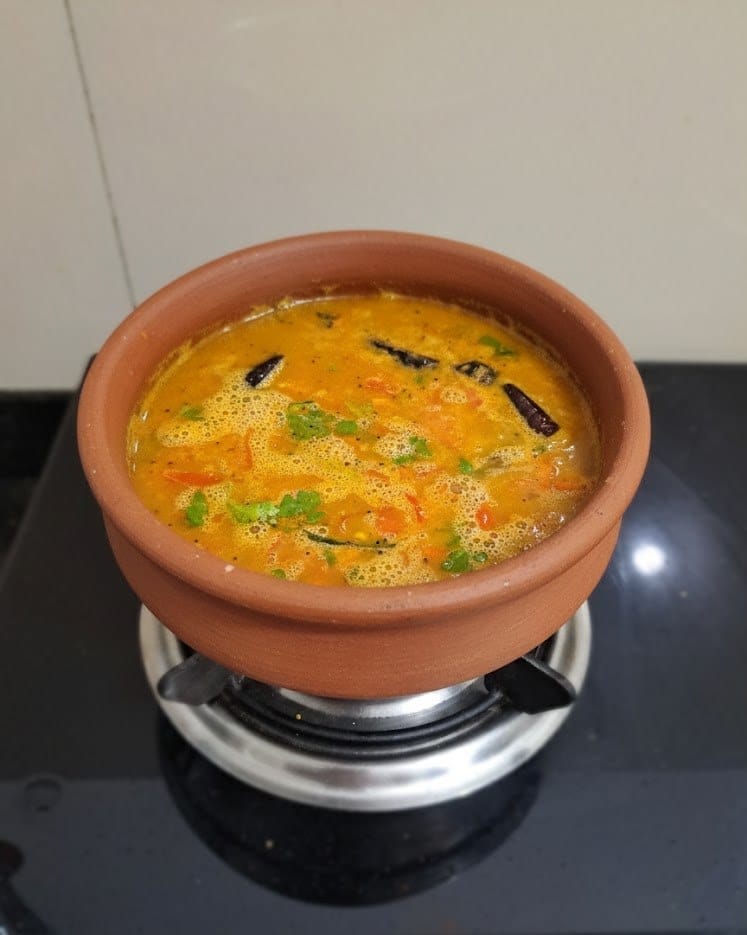 Horse gram rasam for digestion served in a clay pot with fresh coriander, showing a warm and healthy South Indian soup