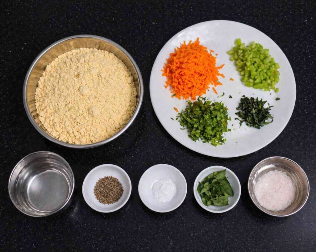 Ingredients for kadalai maavu dosa including besan flour, carrot, capsicum, curry leaves, coriander, and spices