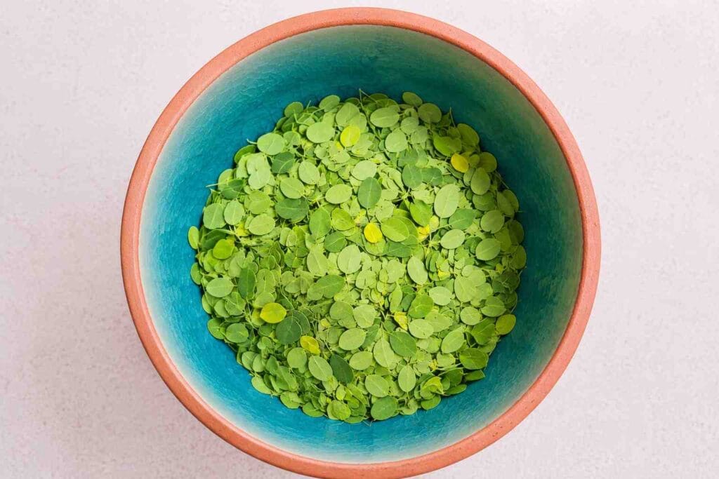 Fresh murungai keerai leaves in a bowl for homemade South Indian moringa soup recipe