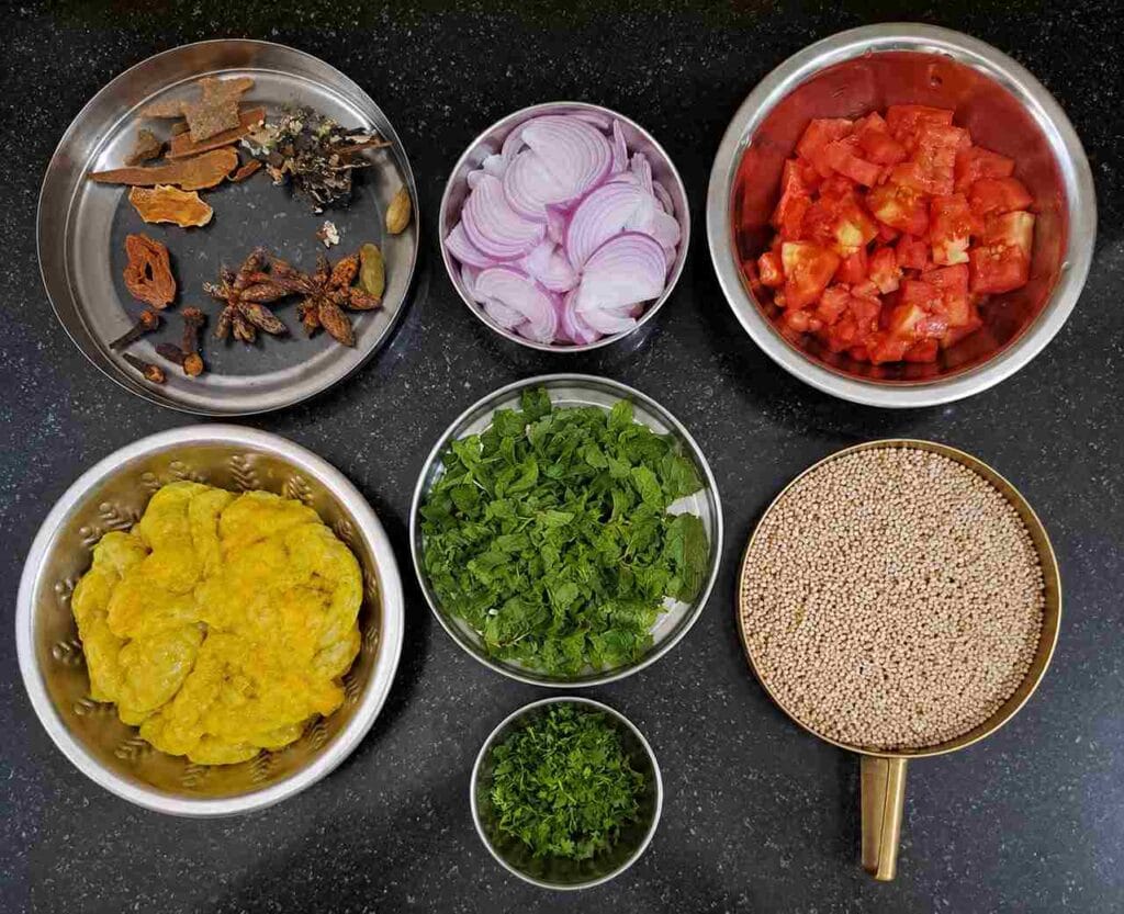 Ingredients used for varagu arisi prawn biryani including prawns, onions, tomatoes, mint, and spices