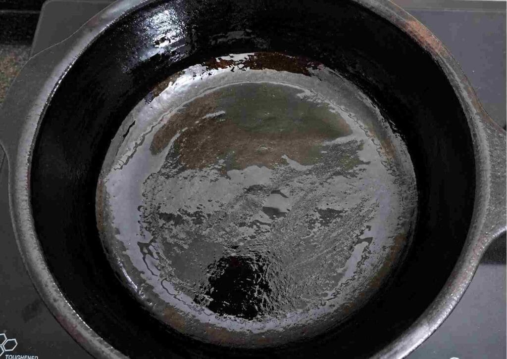 oil applied inside clay pot to absorb into surface and improve durability of earthen cookware before regular use