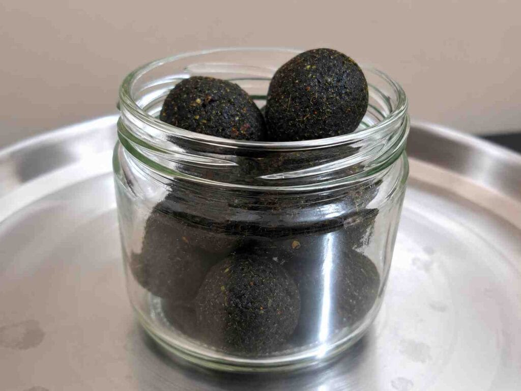 Healthy curry leaves laddus stored in an airtight glass container for everyday snacking