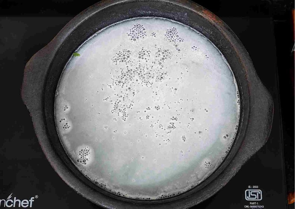 clay pot heating on low flame with water inside to strengthen structure and prepare cookware for regular cooking use