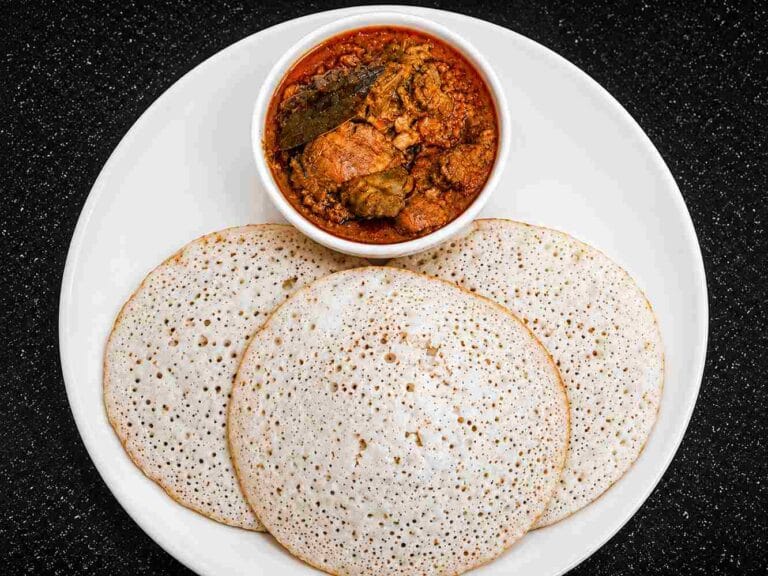 Soft coconut dosa recipe served with spicy gravy showing fluffy and spongy texture.