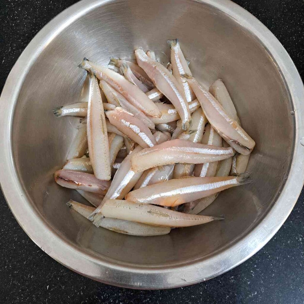 Fresh cleaned nethili fish (anchovies) kept in a steel bowl before marination for crispy South Indian fish fry recipe.
