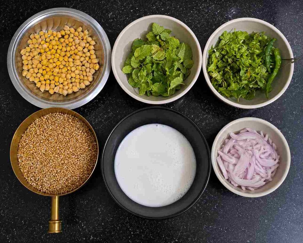 Ingredients needed for Varagu Arisi Kondaikadalai Pulao including kodo millet, chickpeas, coconut milk, herbs and onions