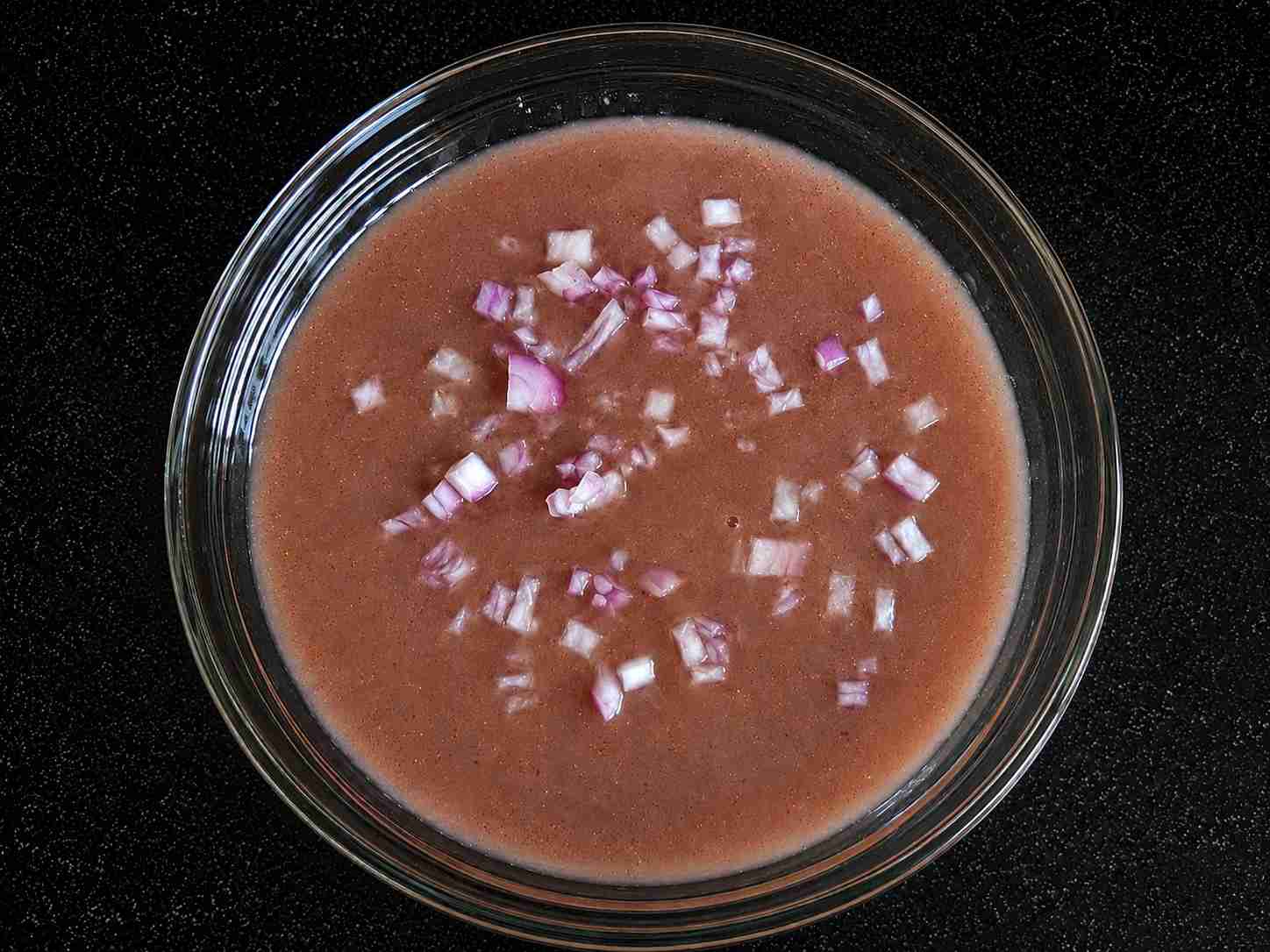 Kullakar Rice Kanji served with chopped onions, a healthy fermented red rice porridge made using homemade Kullakar Rice Kanji Powder.
