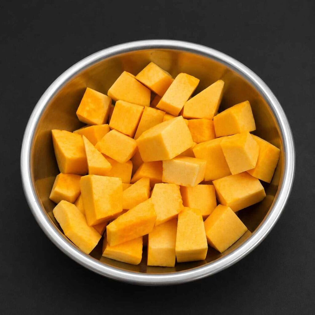 Fresh yellow pumpkin pieces used to make homemade Parangikkai Sambar.