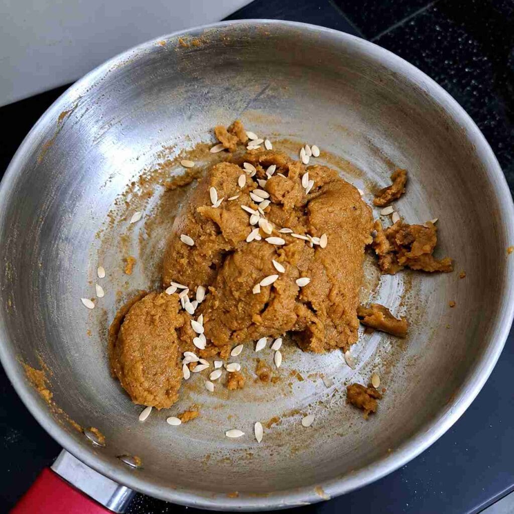 Freshly cooked Aadi Kummayam served in a pan, topped with pumpkin seeds and ready to enjoy as a traditional Tamil sweet.