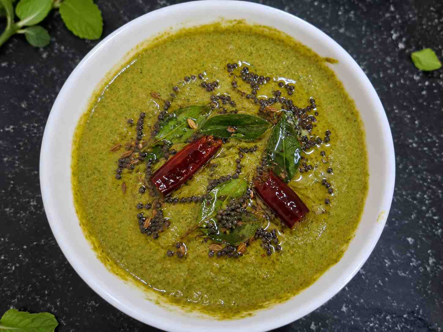 Mint Chutney Recipe served in a bowl with mustard seeds, curry leaves, and dried red chillies, an easy South Indian pudina chutney without coconut for dosa, idli, chapati, and sandwiches.