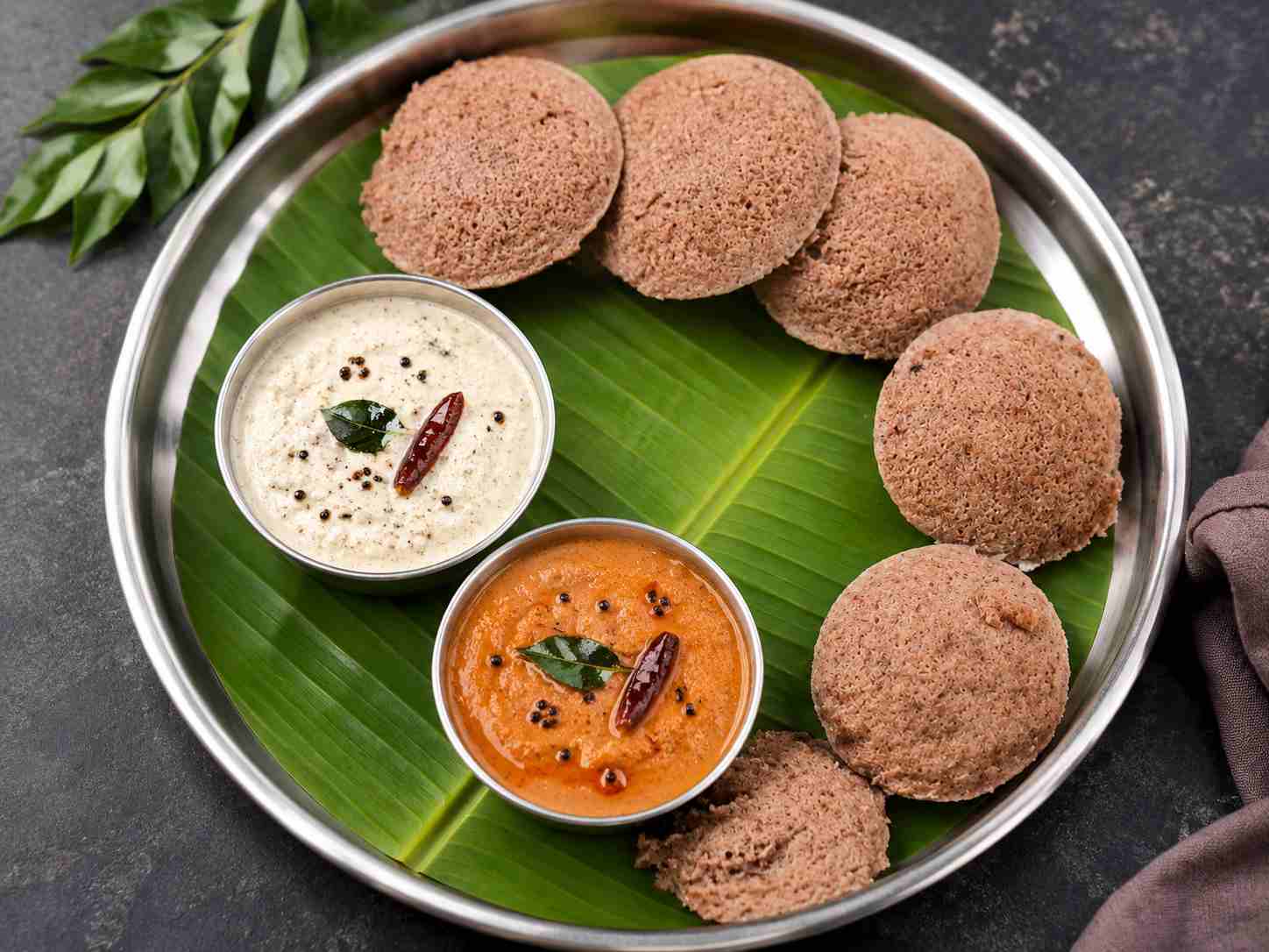 Soft Red Cholam Idli served with coconut chutney and tomato chutney made from homemade fermented millet batter