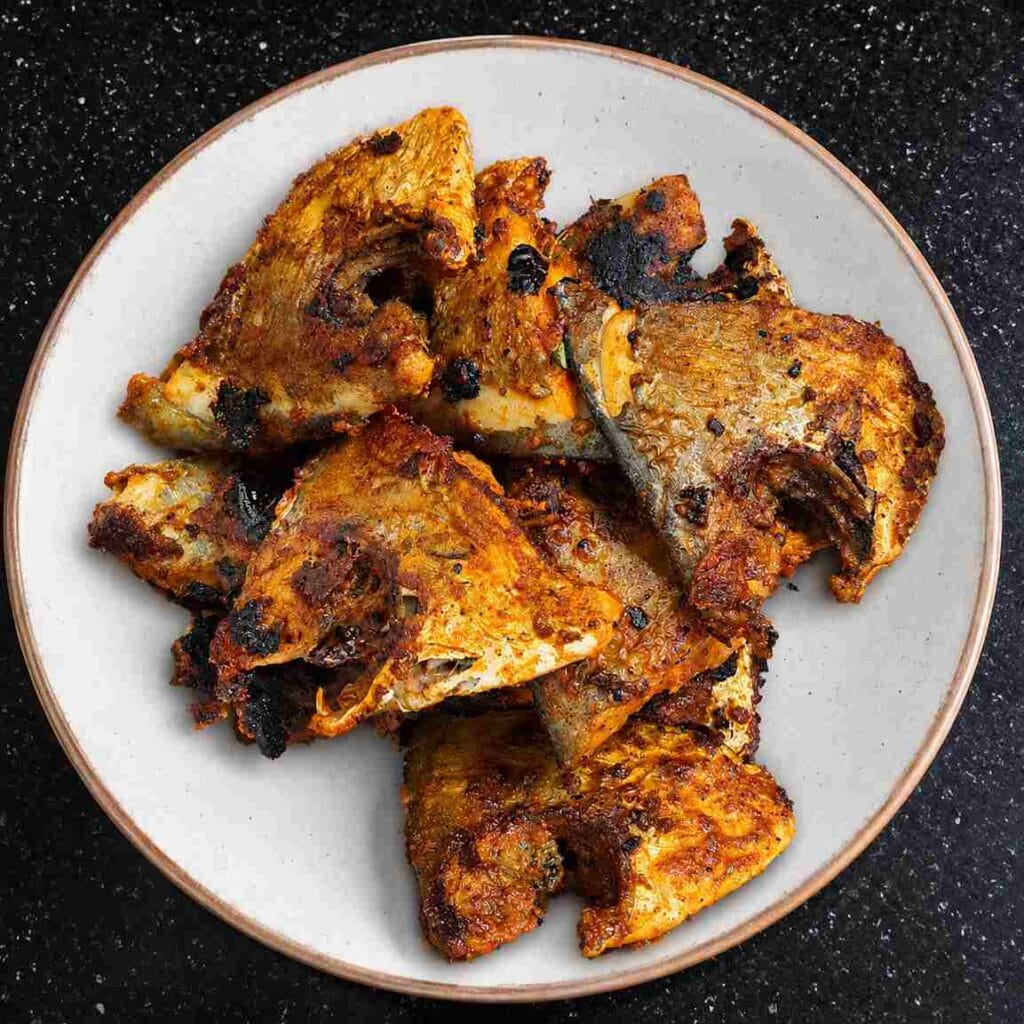 Golden fried Vavval Meen pieces arranged on a white plate